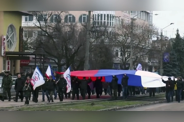 Активисты несут российский флаг по Евпатории.