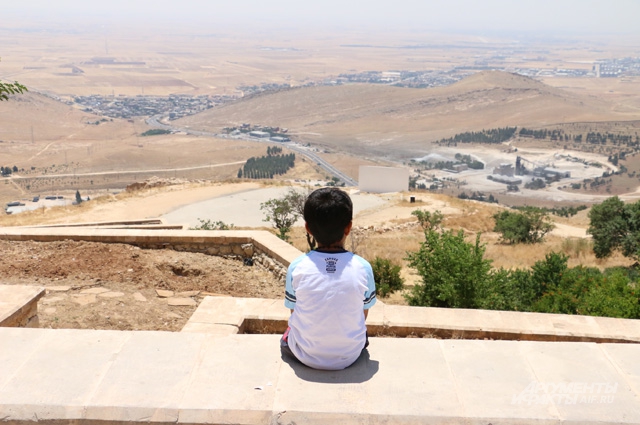 Езидский мальчик смотрит на долину, где когда-то располагались уничтоженные ныне деревни его предков.