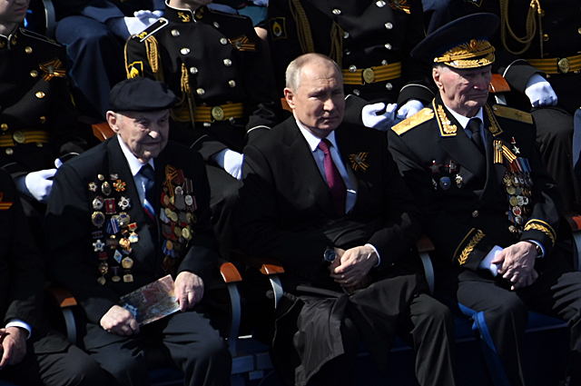 Президент РФ Владимир Путин и гости наблюдают с трибун на Красной площади за ходом парада в Москве