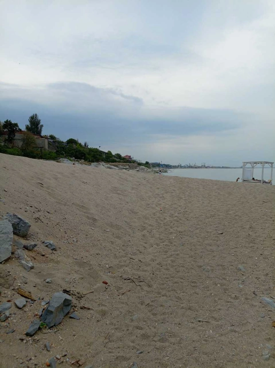 Внутри берег покрыт крупными ракушками и мусором.