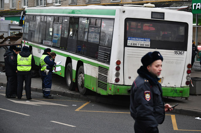 Сотрудники правоохранительных органов у пассажирского автобуса, въехавшего в остановку на Сходненской улице в Москве.