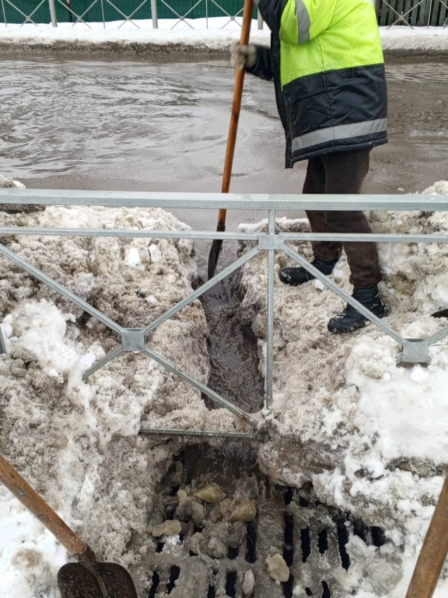 Коммунальные службы очищают ото льда ливневки, чтобы в них ушла вода