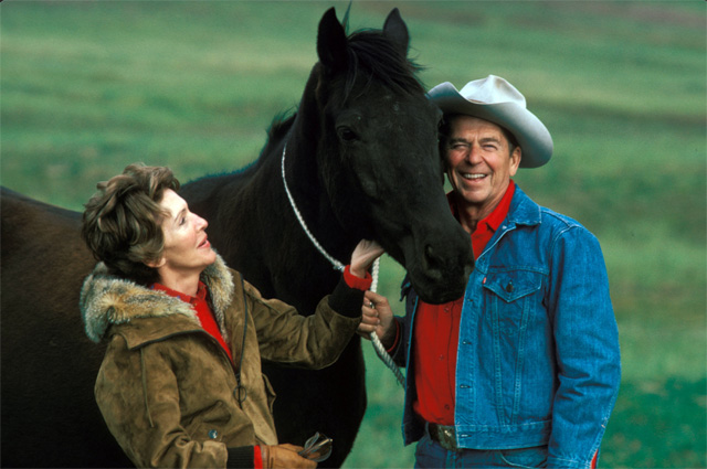 15 июня 1980 г. Санта-Барбара, Калифорния, США — губернатор Рональд Реган в своей культовой ковбойской шляпе стоит рядом со своей женой Нэнси Реган с одной из их лошадей на территории их ранчо (Ранчо дель Сьело) во время президентской гонки в 1980 году.
