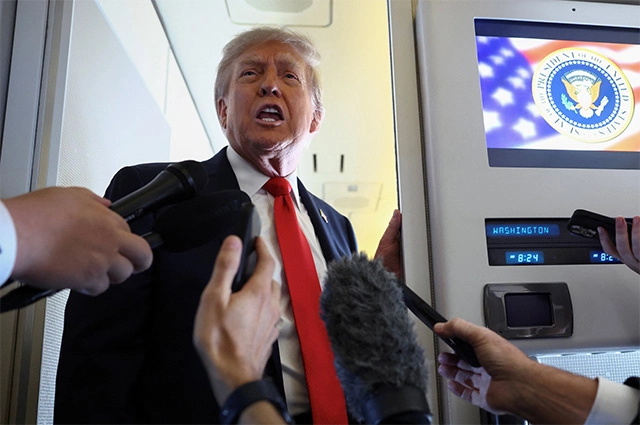 Президент США Дональд Трамп общается с журналистами на борту президентского самолета по пути на Аляску.