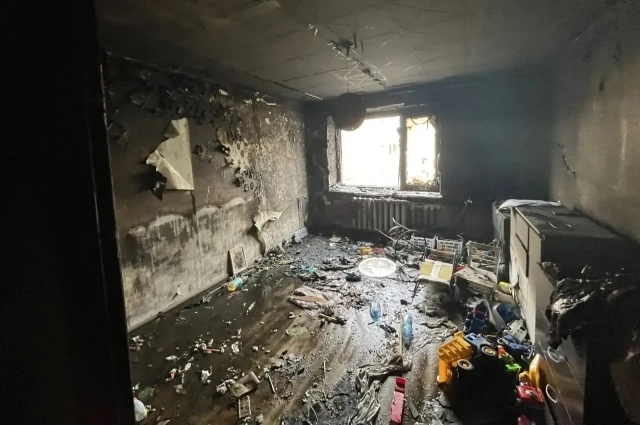 В пустой, обгоревшей комнате, остались лишь разбросанные игрушки /