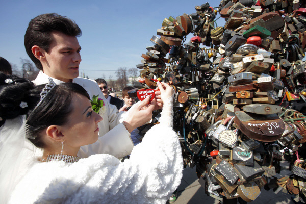 Молодожёны на Лужковом мосту у дерева любви, где прошли свадебные гулянья накануне праздника Красной горки