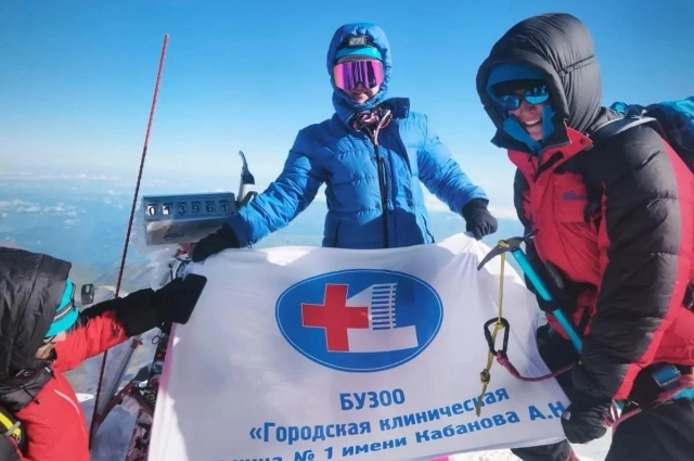 На высоте Наталья развернула флаг своей больницы.