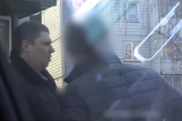 На видео с задержания мужчина забирает от предполагаемого посредника белый конверт 