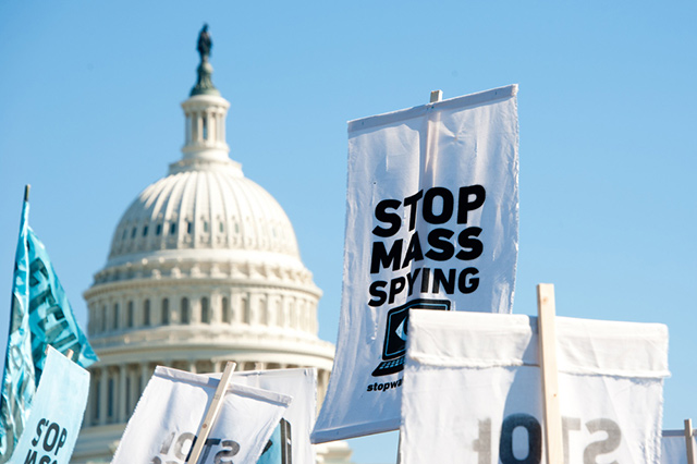  Остановите массовую слежку надпись на плакате во время массовой демонстрации против политики АНБ. Вашингтон, октябрь 2013 года