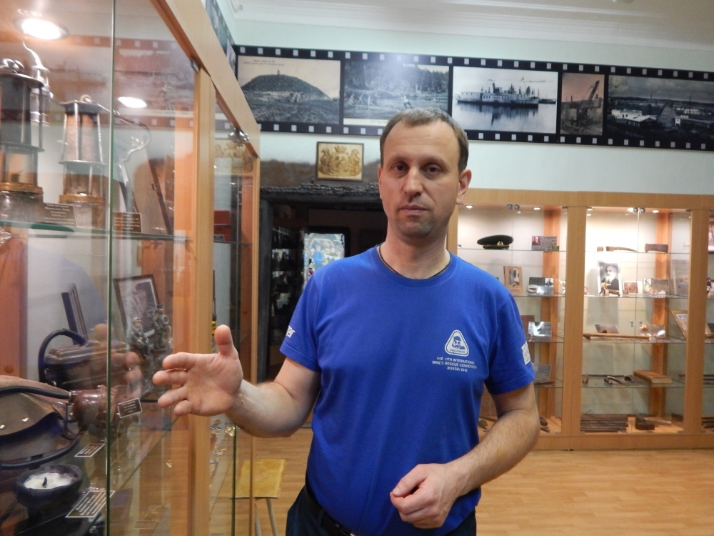 Михаил Цыганко в своём музее, возле стойки с различными светильниками, рассказывает о том, когда начал интересоваться камнями.