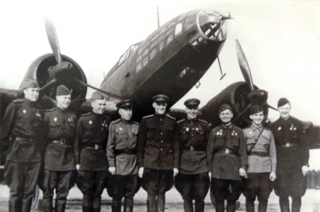   Николай Жуган с сослуживцами на фоне бомбардировщика ИЛ-4, на котором он летал в годы войны. 