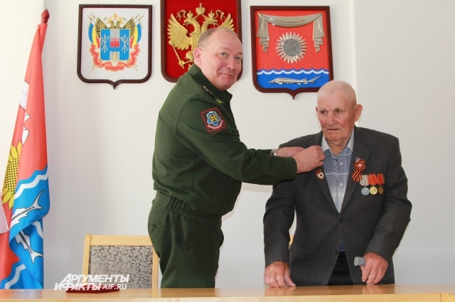 Командующий ЮВО прикрепляет орден к пиджаку Тихомирова. 