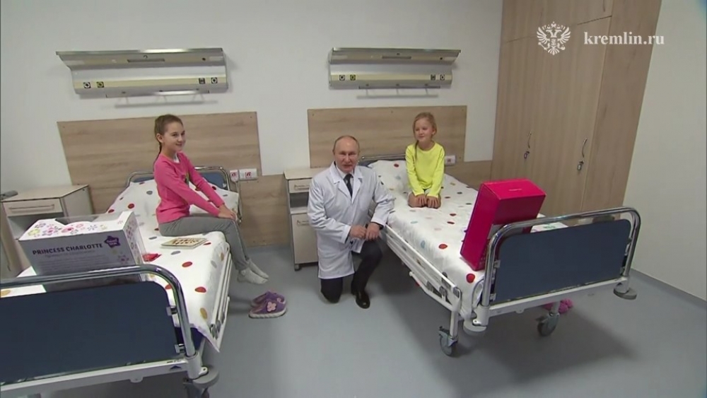 Чтобы поместиться в кадре, Владимир Путин присел и облокотился на кровать Евы.