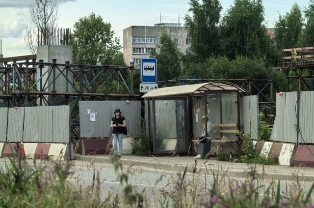 Остановка общественного транспорта скрыта за заборами стройплощадки.