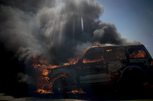 Легковой автомобиль в районе Луганска, загоревшийся в результате попадания снаряда во время артиллерийского обстрела украинскими силовиками