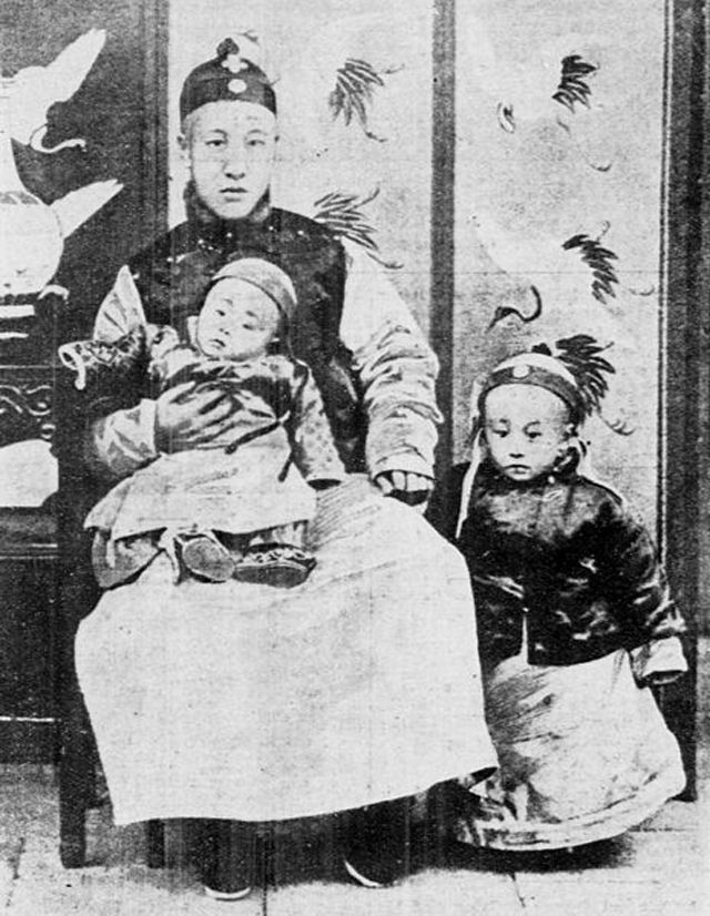 Пу И, 3 года (справа), стоит рядом со своим отцом ( Цзайфэн ) и младшим братом Пу Джи.