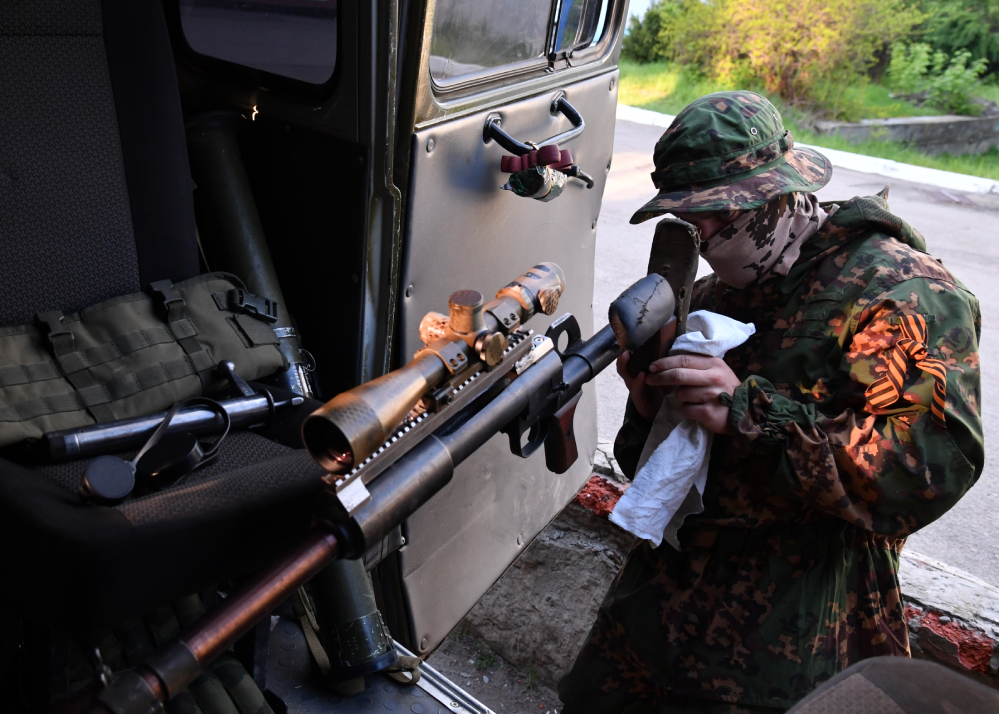 A member of a sniper platoon of the Ministry of Internal Affairs of the LPR wipes a Degtyarev anti-tank rifle (PTRD).