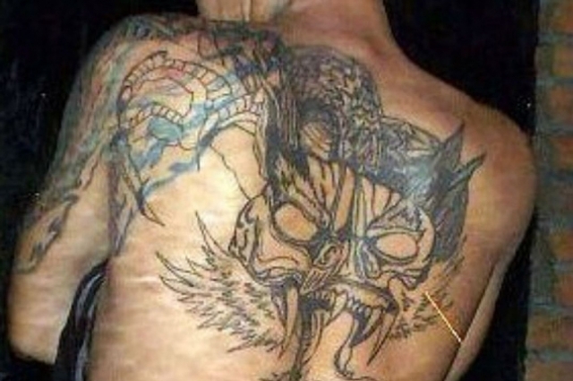 На спине  - огромная татуировка дракона.
