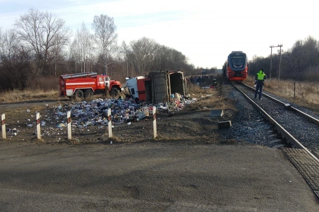 На фото видно пожарную машину и опрокинувшийся набок грузовик.