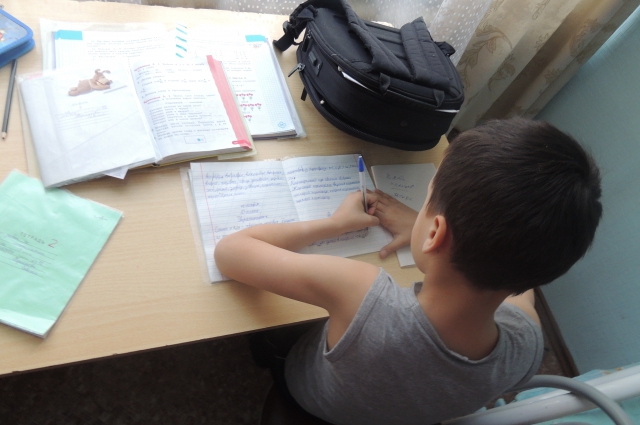 Этот малыш, что так старательно пишет в тетради, в школу не ходил почти год: было не в чем.