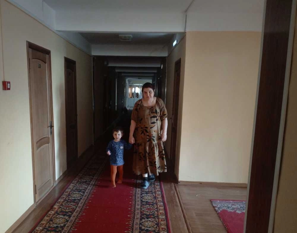 Динара Дадашева прогуливается с младшей внучкой по гостиничному коридору.