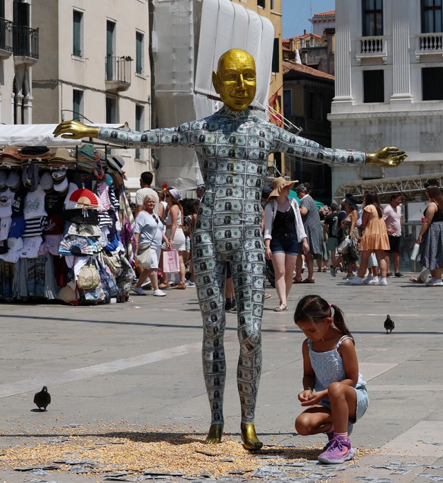 Манекен, изображающий основателя Amazon Джеффа Безоса, покрытый фальшивыми долларовыми купюрами на площади Святого Марка.