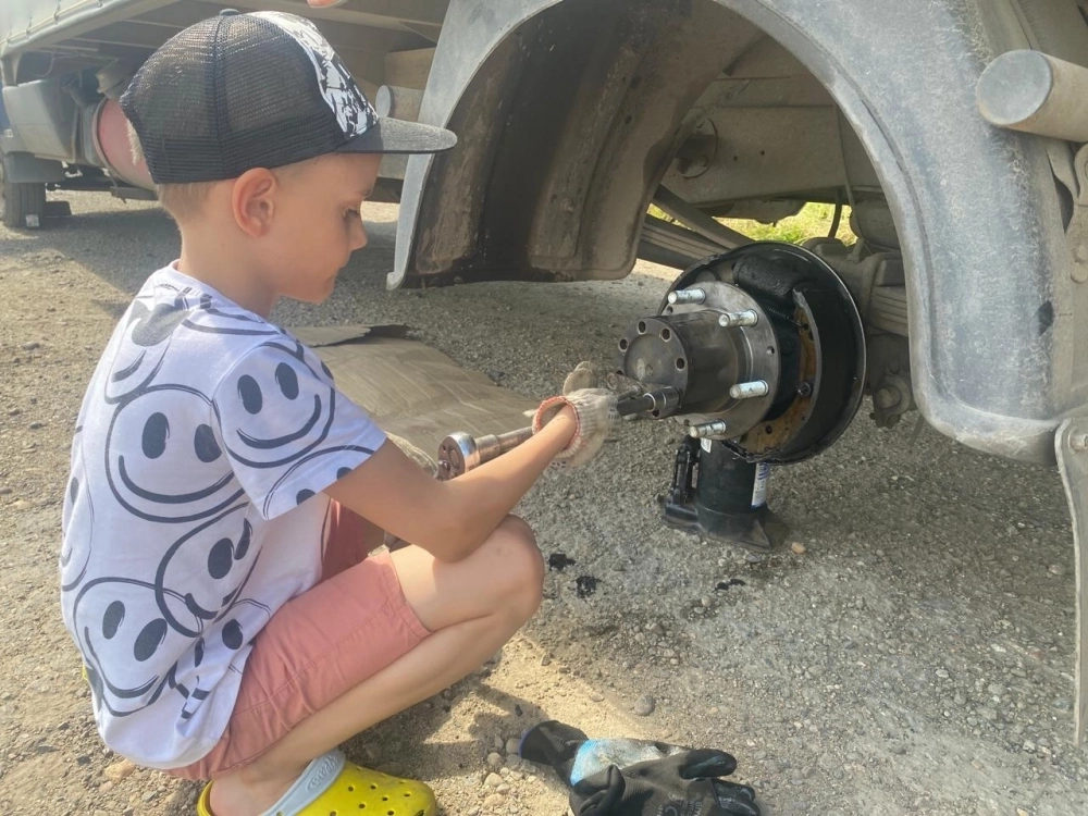 Сын помогает Павлу чинить машину после поездок.