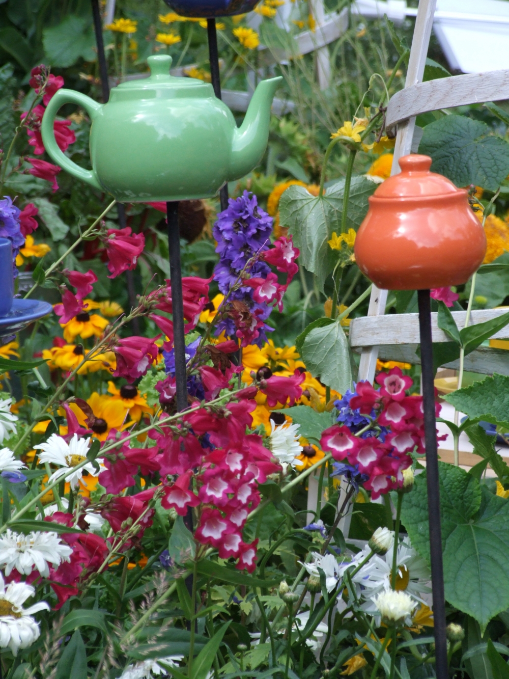 Яркий чайный сервиз – украшение цветника.