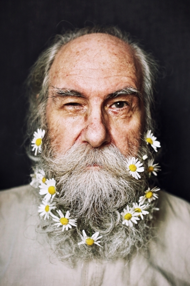 Внучка украшает бороду дедушки Бориса цветами.