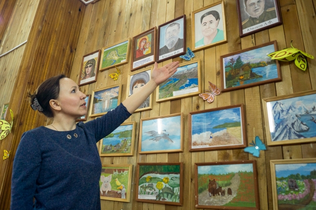 Дочь Анжела показывает картины Валентины Абрамовны, которые она иногда рисует, лёжа в подсобке сельсовета.