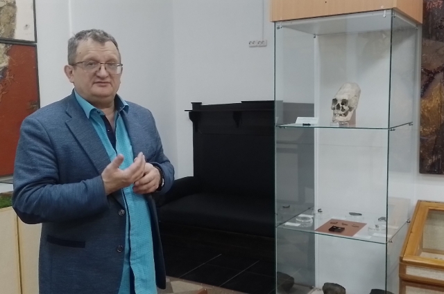 Руководитель музея просвещения Игорь Скандаков у своей находки - удлинённый череп был найден во время раскопок в Усть-Таре. 