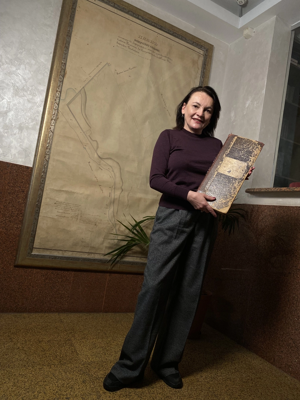 Анна Круглова с книгой регистрации захоронений в руках