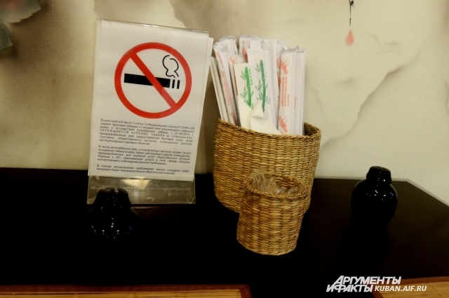 Угрожающая табличка о запрете курения стоит на каждом столике в любом кафе
