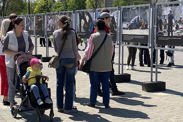Жители на площади Свободы в Херсоне, где открылась фотовыставка о преступлениях ВСУ в Донбассе.