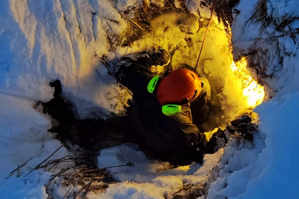 Спасатели спускаются в пещеру.