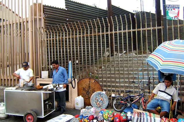Американо-мексиканская стена возле пешеходного перехода через границу в городе Тихуана (за забором - Сан-Диего)