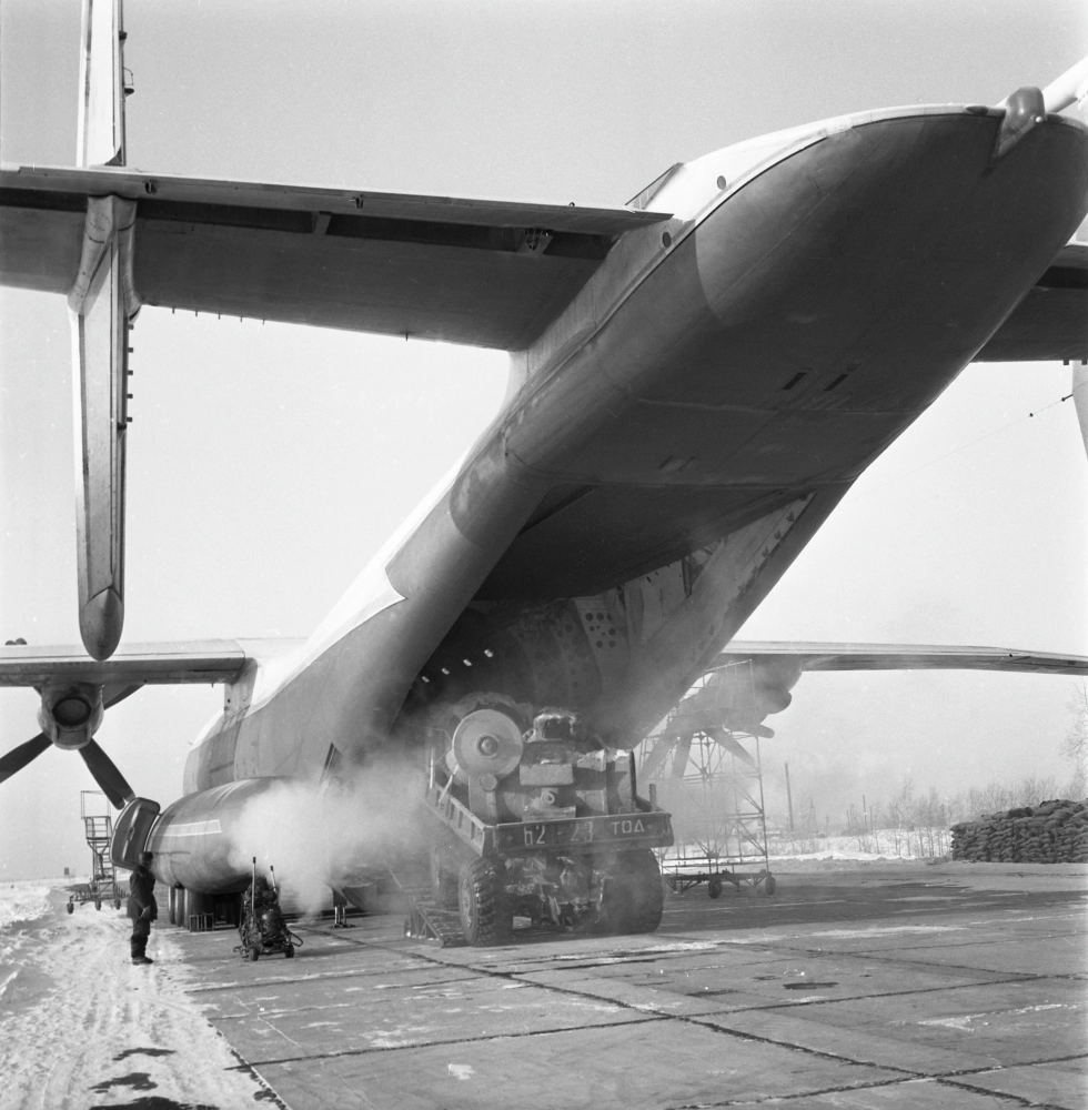 Советский тяжёлый турбовинтовой транспортный самолет Ан-22 («Антей»), разработанный ОКБ Олега Константиновича Антонова. Загрузка самолета «Антей» на таежном аэродроме.