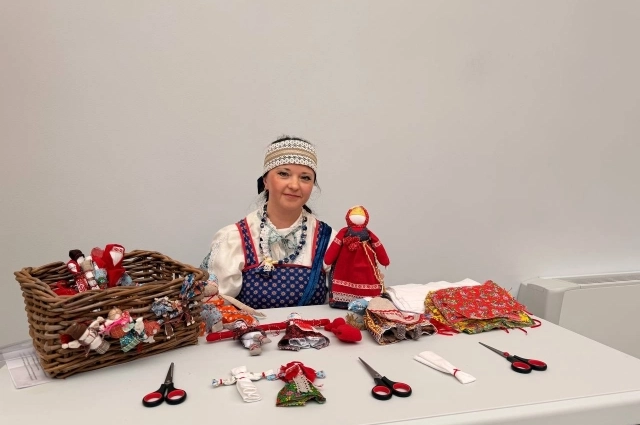 Мария Митинева учит гостей делать куклы.