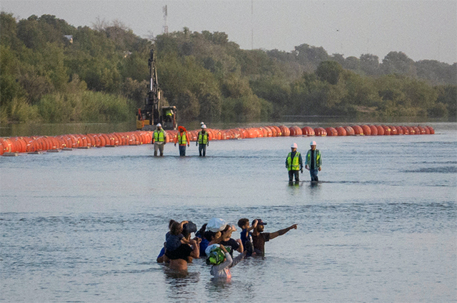 Cемьи мигрантов плывут по реке Рио-Гранде в поисках точки въезда в Соединенные Штаты из Мексики в Игл-Пасс, штат Техас