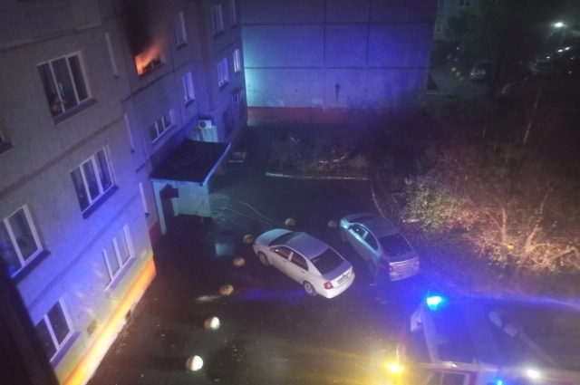Пожар, когда огнеборцы приступили к работе. В окнах люди. На фото видно, на каком расстоянии от дома находится спецтехника.