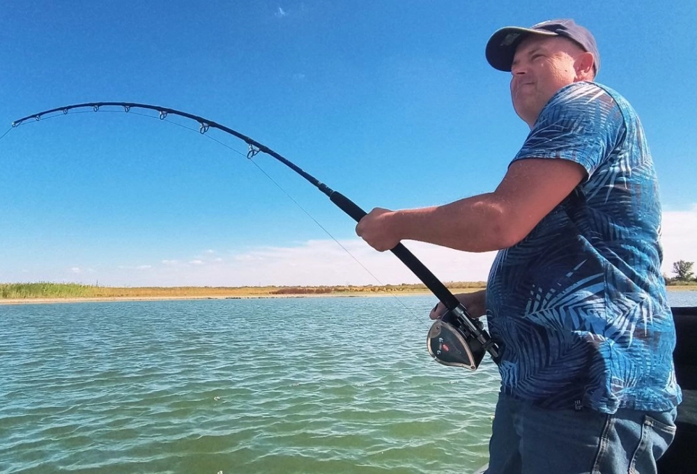 Рыбак ловит сома-гиганта